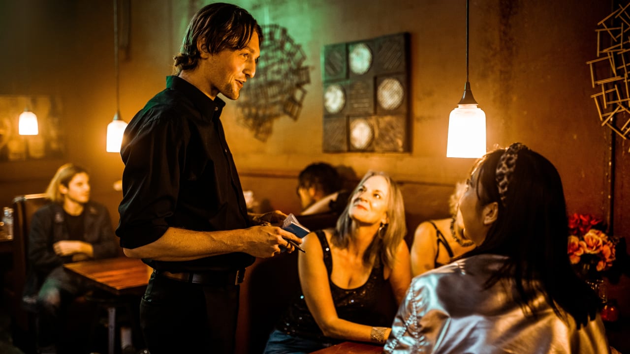 evening waiter taking orders from two ladies.