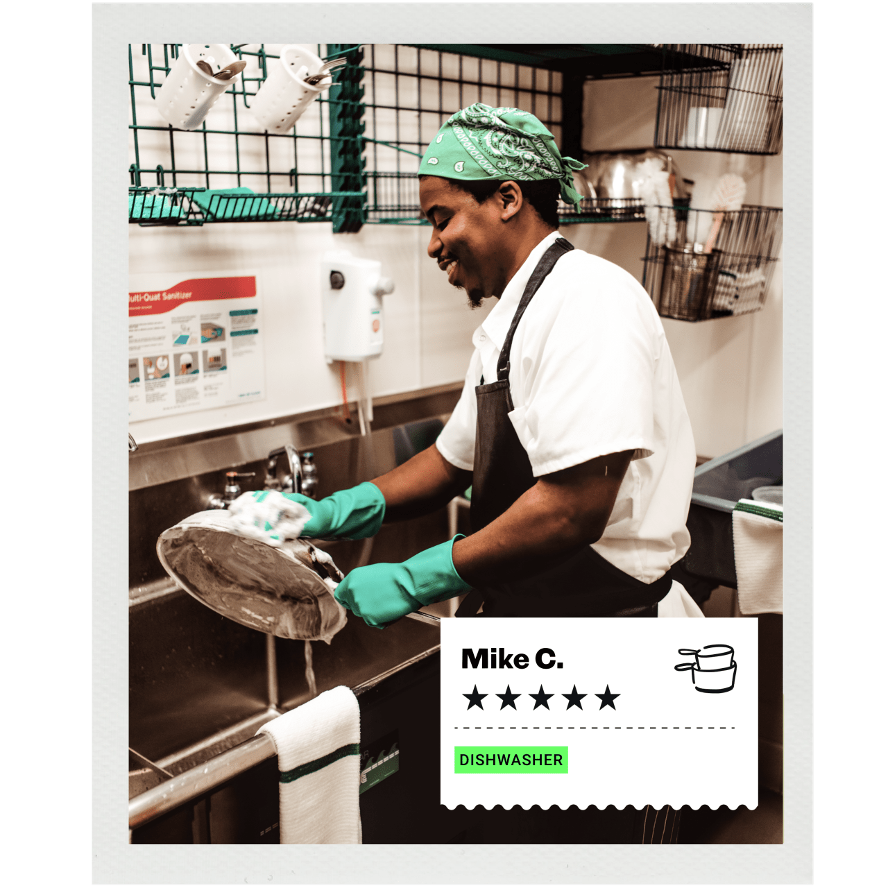 Dishwasher in gloves cleaning a dish at a kitchen sink.