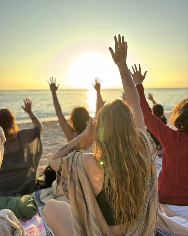 Women greeting the sunrise on the beach near Tulum