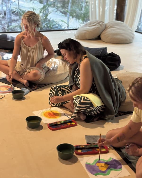 Shamanic art making with paint and brushes on the shala floor