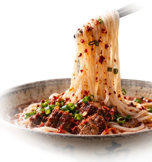 Chopsticks lifting rice noodles above a bowl with beef and chili