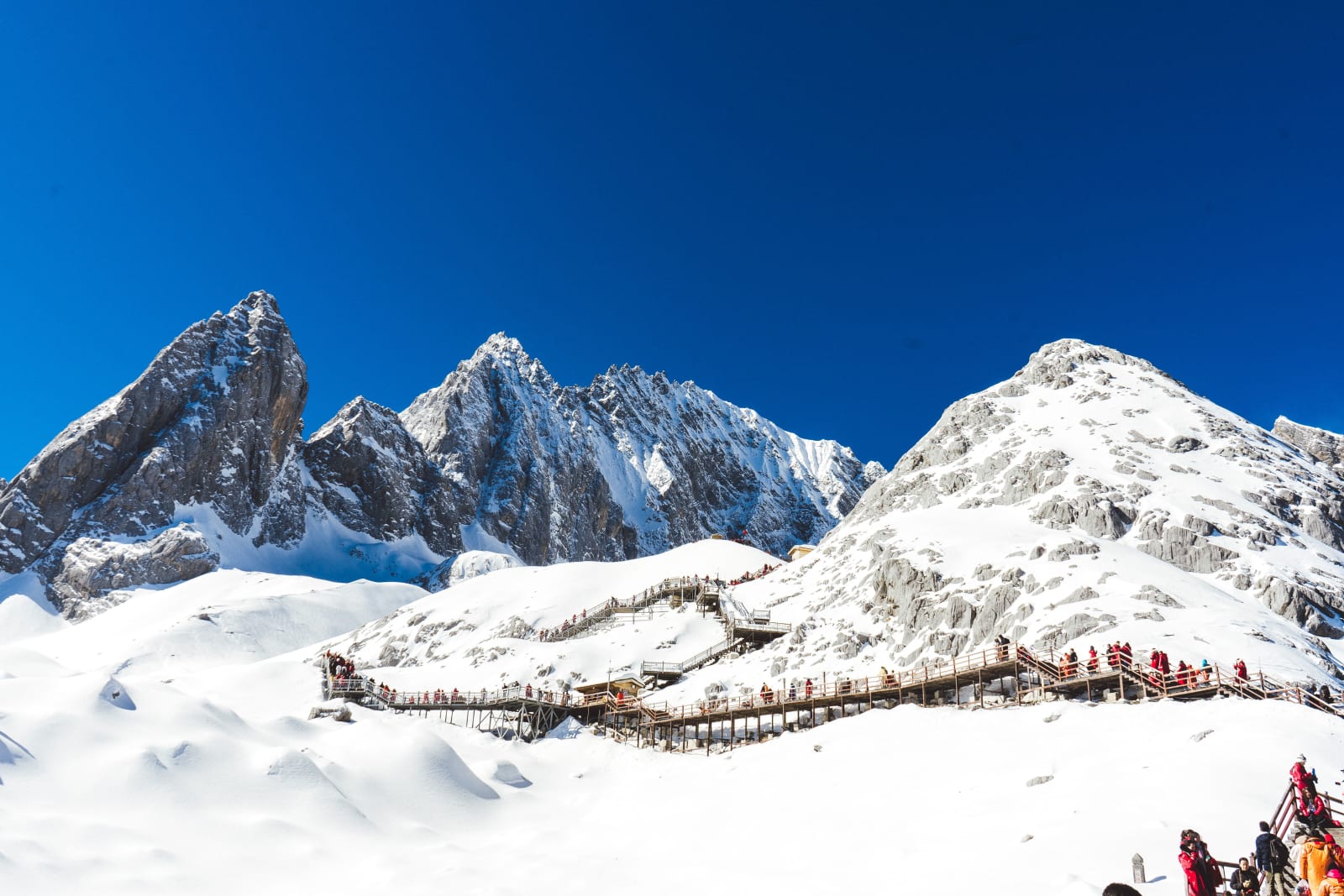 A wooden walkway below a snow-covered peak near Lijiang, China