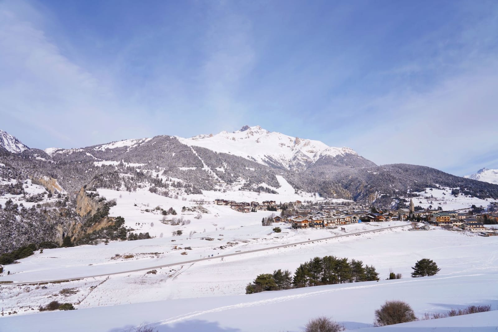 Aerial view of snow-covered mountains and village in Aussois, France during winter.
