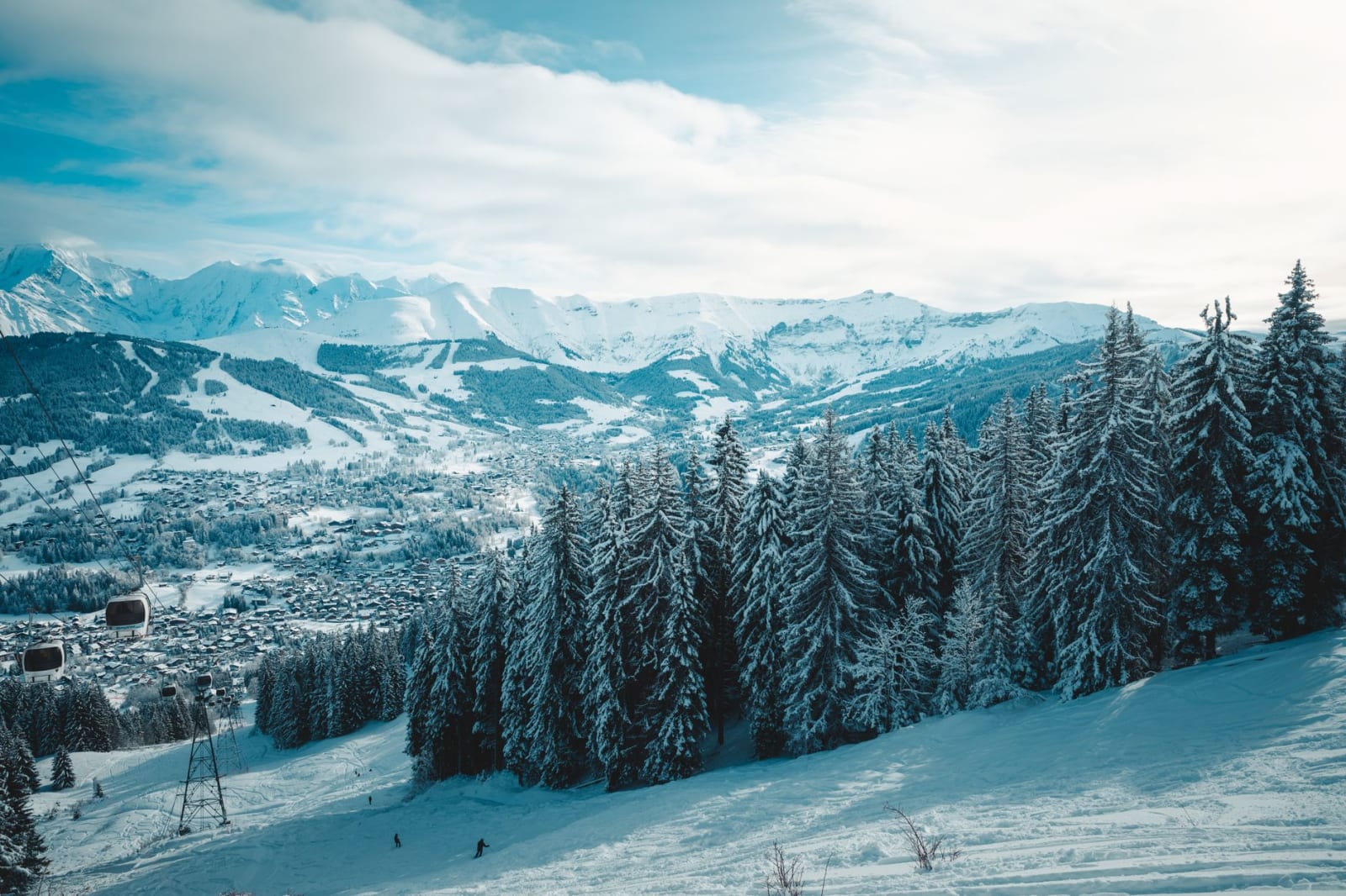 Breathtaking view of snow-covered trees and mountains in Megève, France, capturing winter's serene beauty.