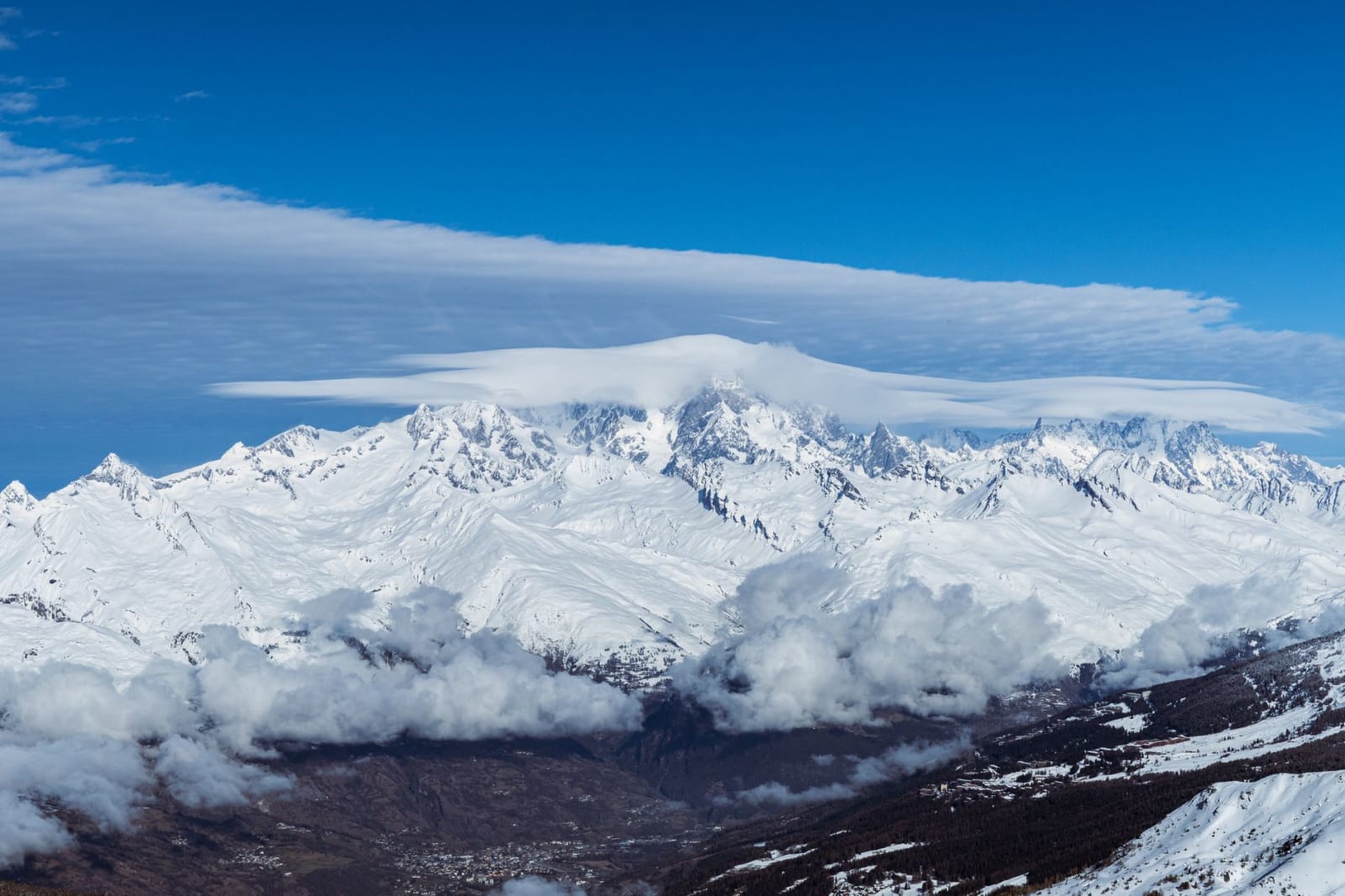 Breathtaking snowy view of La Plagne-Tarentaise mountains under a vibrant blue sky.