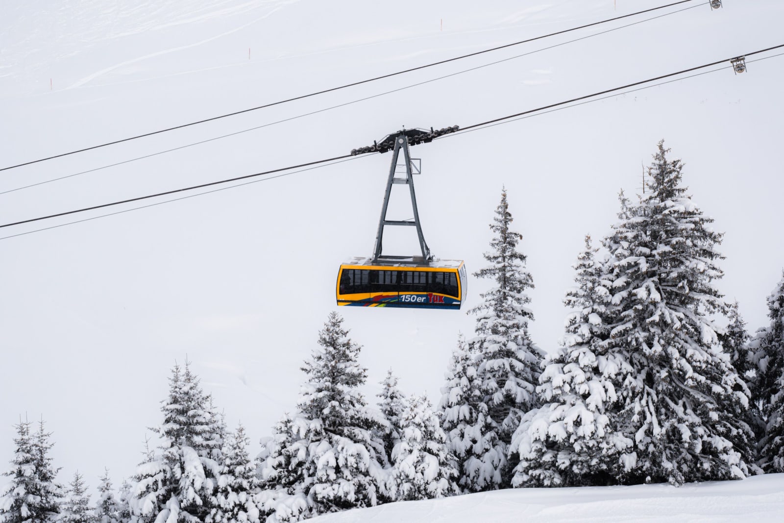 A cable car over snowy forest in Mayrhofen