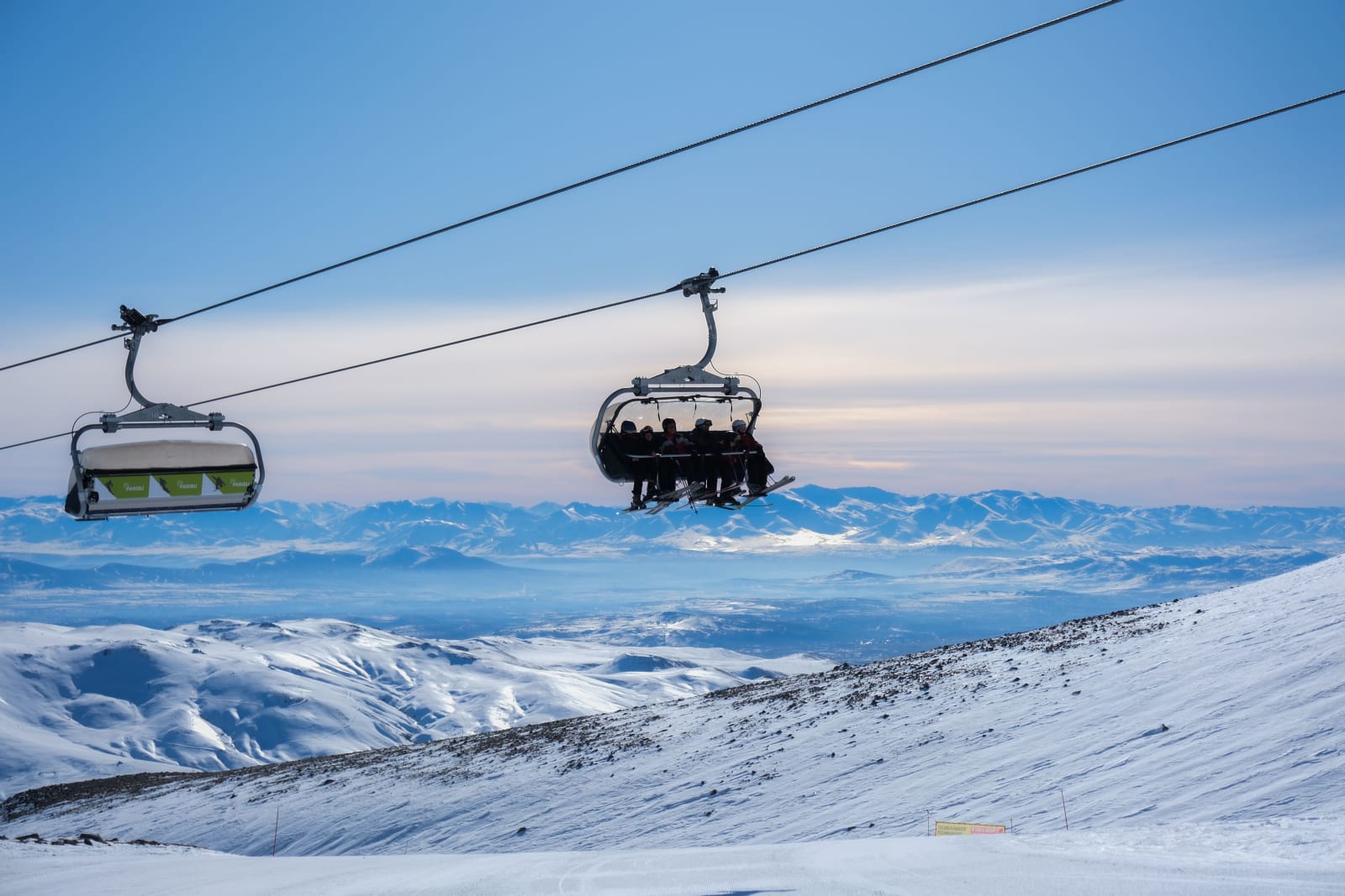 A cable car over snowy mountains at sunset at a Turkish ski resort