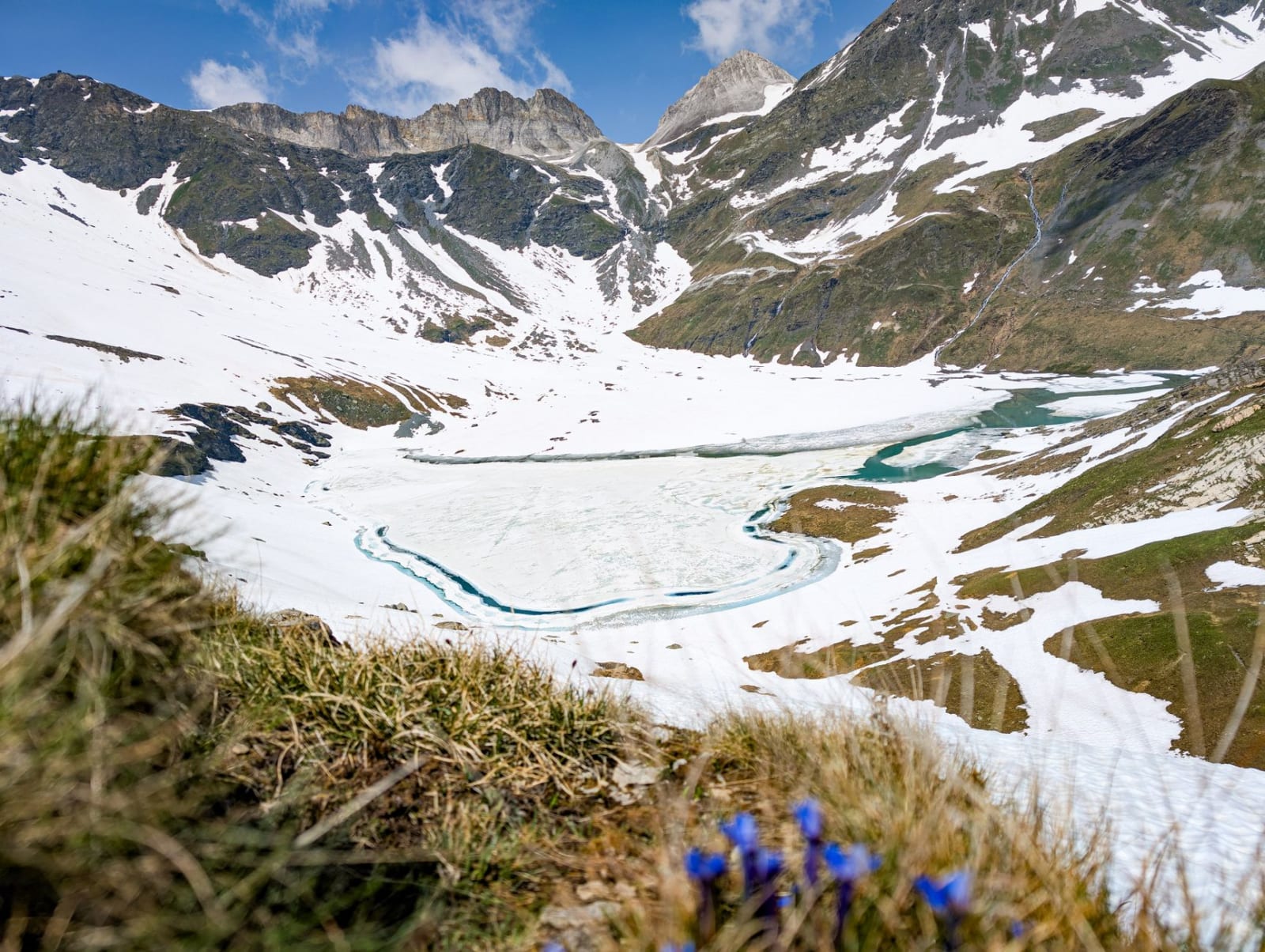 Scenic view of a frozen lake surrounded by snow-capped mountains in Pralognan-la-Vanoise, France.