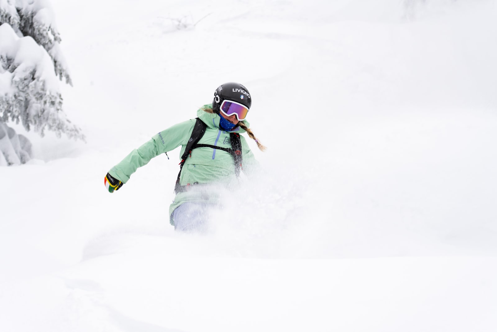 A snowboarder carving through fresh powder