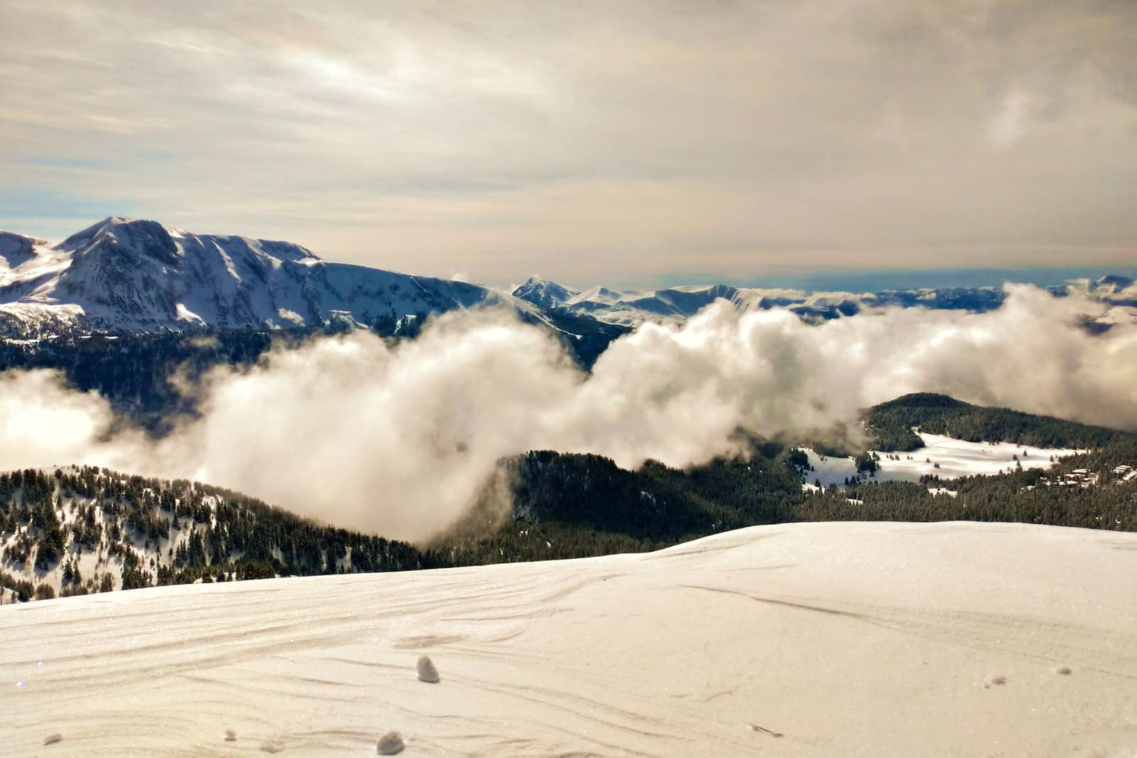 Stunning view of snow-covered mountains and fog in Chamrousse, France, perfect for winter travel inspiration.
