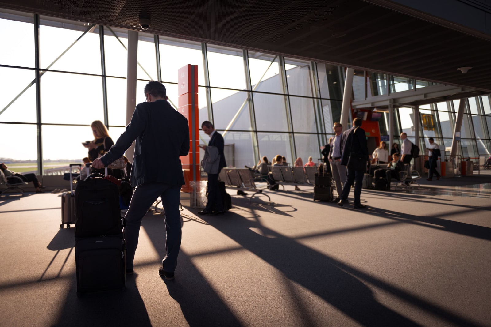 Travellers with luggage in a busy airport terminal