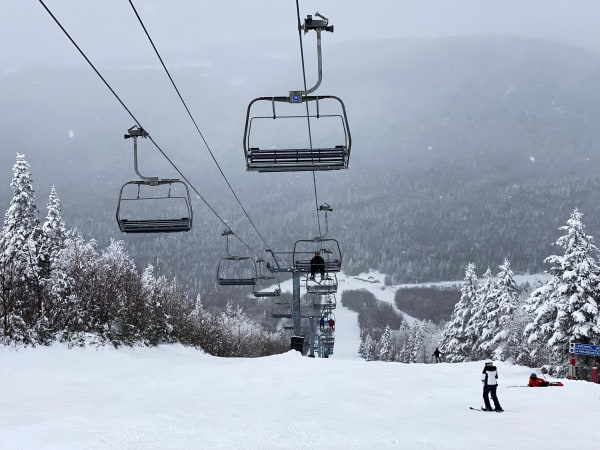 Skiers, a cable car and snowy mountains at Beaupré, Quebec