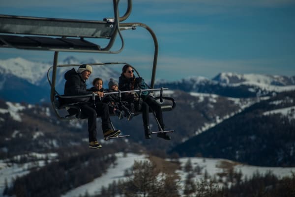 Illustrative photo: karim desouki / Pexels Family having fun on a ski lift with snow-covered mountains in the background during a sunny winter day.