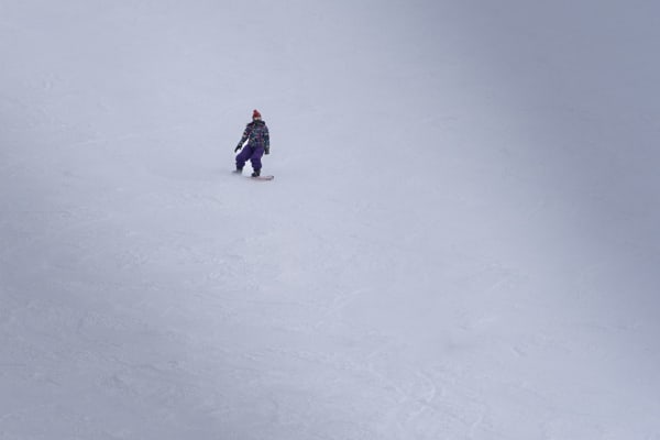 Illustrative photo: 家豪 陳 / Pexels A single snowboarder rides down a vast snowy slope, showcasing winter adventure and solitude.