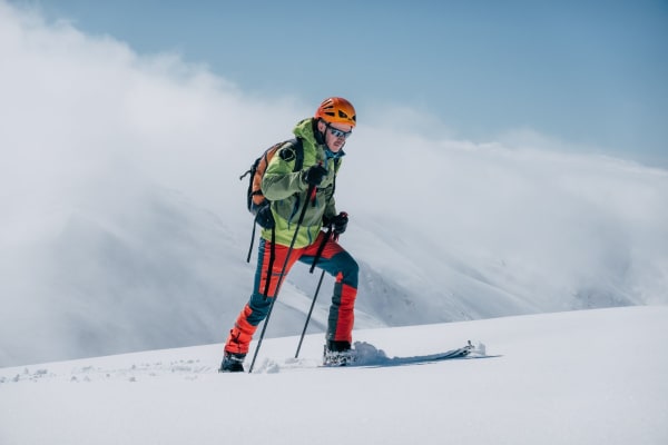 Illustrative photo: Jordi Costa Tomé / Pexels A skier trekking uphill on a snowy mountain in bright winter gear, under a clear sky.