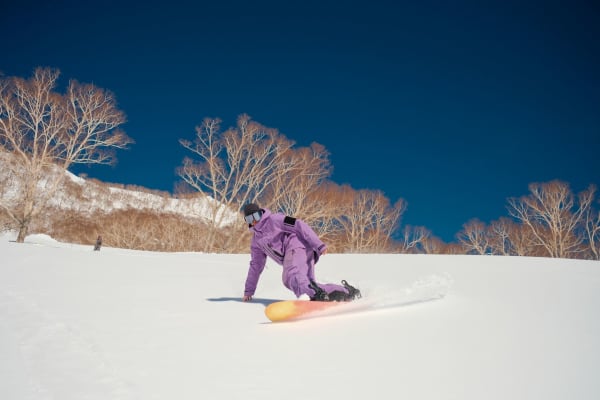 Illustrative photo: Shashank Brahmavar / Pexels Snowboarder in vibrant attire carving through fresh snow in Hakuba, Japan.