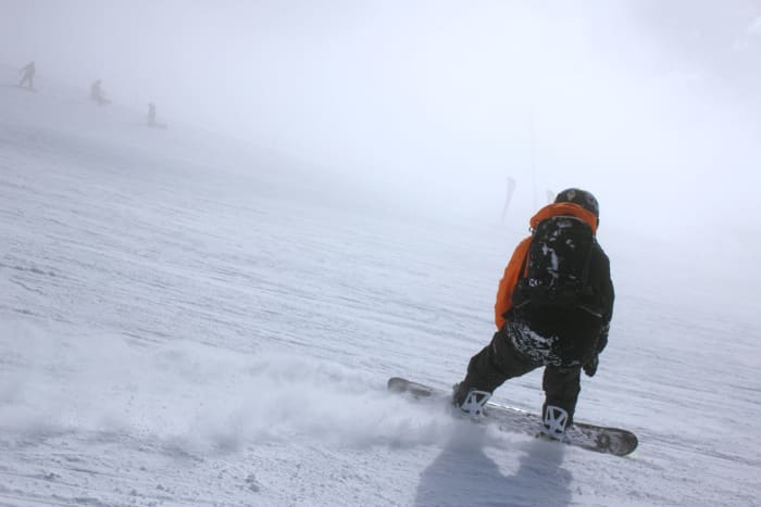 Dynamic snowboarding action shot in a snowy mountain landscape showcasing winter sports and adventure.