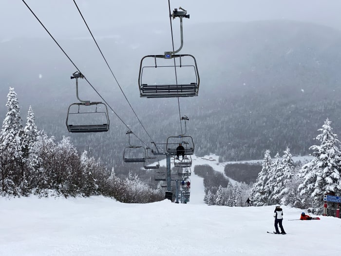 Skiers, a cable car and snowy mountains at Beaupré, Quebec