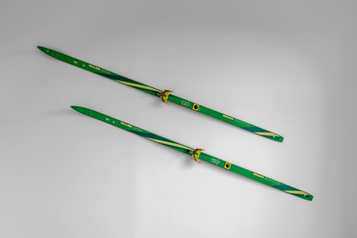 Pair of green cross-country skis placed on a white background, ideal for winter sports themes.