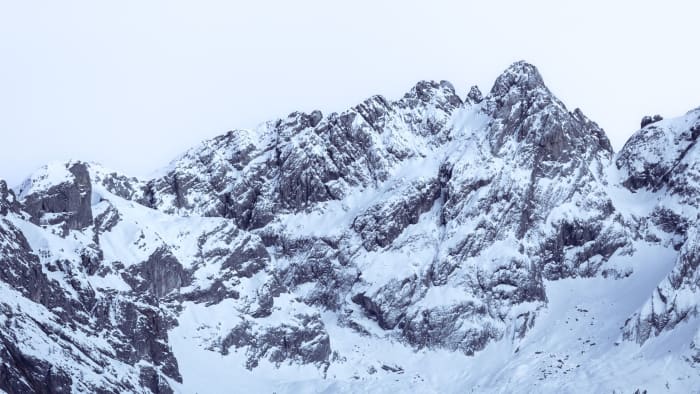 A breathtaking view of snow-covered mountain peaks under a clear winter sky, perfect for nature enthusiasts.