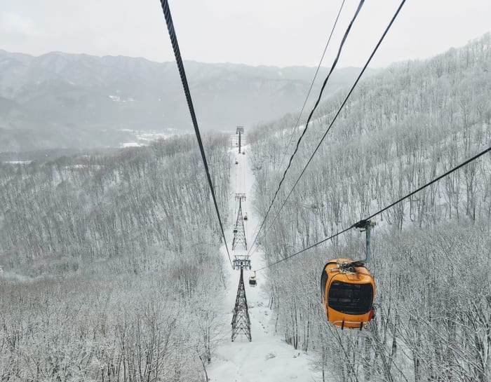 Cable car journey over snow-covered forests in Hakuba, Nagano, Japan, during winter.