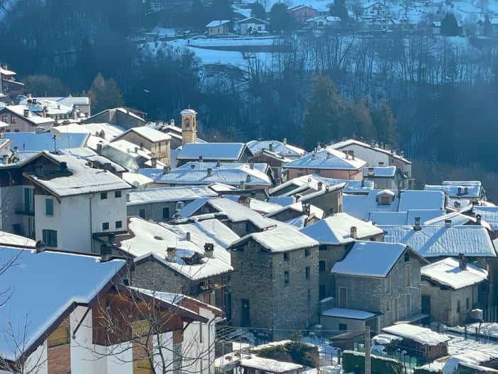 A picturesque village with snow-covered roofs in a serene winter landscape.