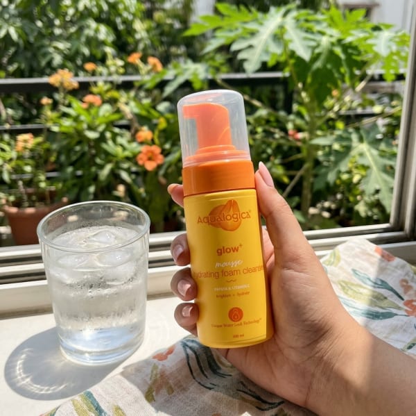 Aqualogica Aqualogica Glow+ Mousse Hydrating Foam Cleanser - 100 ml held in hand, candid photo