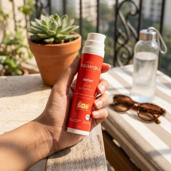 Aqualogica FREEBIE | Detan+ Dewy Sunscreen with SPF 50+ & PA++++ for UVA/B & Blue Light Protection & No White Cast - 50g held in hand, candid photo