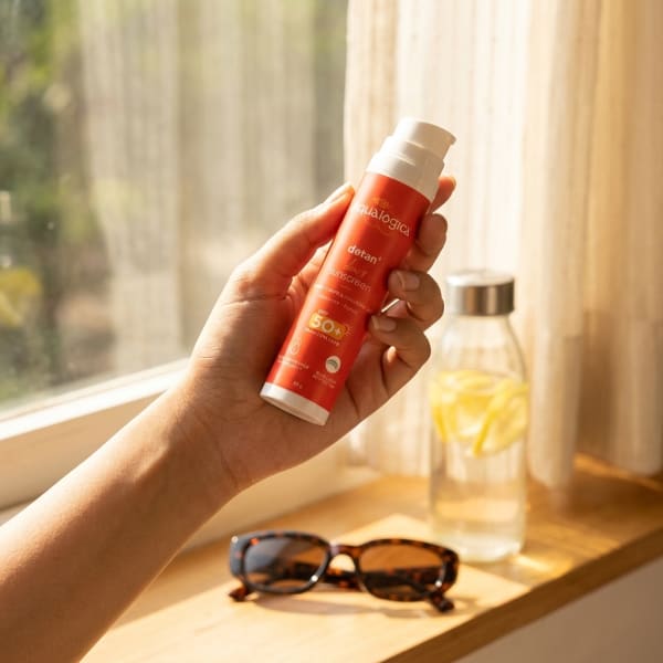 Aqualogica FREEBIE | Detan+ Dewy Sunscreen with SPF 50+ & PA++++ for UVA/B & Blue Light Protection & No White Cast - 50g held in hand, candid photo