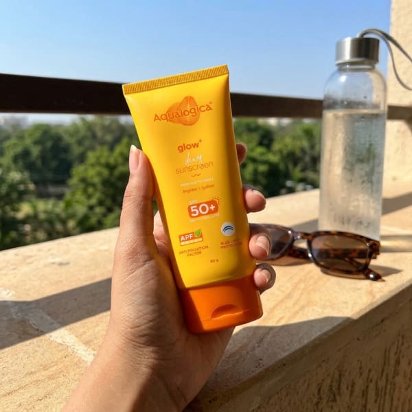 Aqualogica FREEBIE | Glow+ Dewy Sunscreen with SPF 50+ & PA++++ for UVA/B & Blue Light Protection & No White Cast - 80g held in hand, candid photo