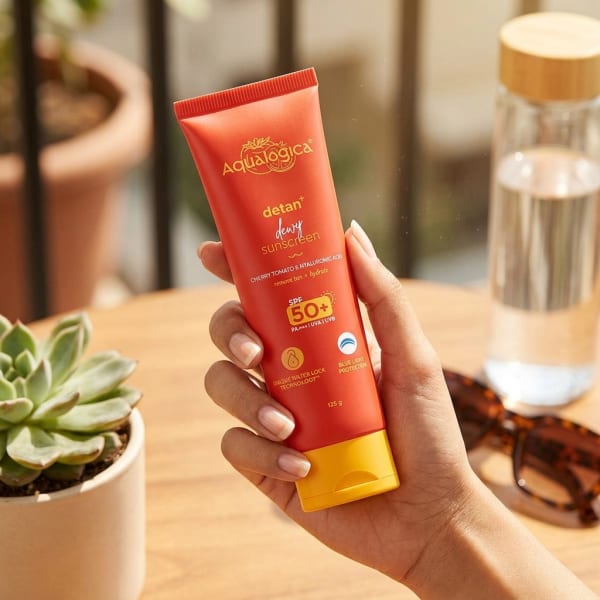 Aqualogica FREEBIE - Detan+ Dewy Sunscreen, 125g held in hand, candid photo