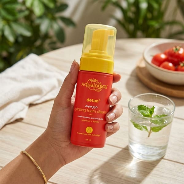 Aqualogica Detan+ Mousse Hydrating Foam Cleanser- 100 ml held in hand, candid photo
