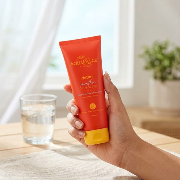 Aqualogica Detan+ Smoothie Face Wash with Cherry Tomato & Glycolic Acid for Tan Removal - 100ml held in hand, candid photo