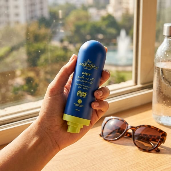 Aqualogica FREEBIE - Bright+ Makeup-Set Sunscreen Mist SPF 50+ PA++++ with Blueberry & Kojic Acid held in hand, candid photo