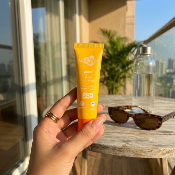 Aqualogica FREEBIE - Glow+ Dewy Sunscreen 15g held in hand, candid photo