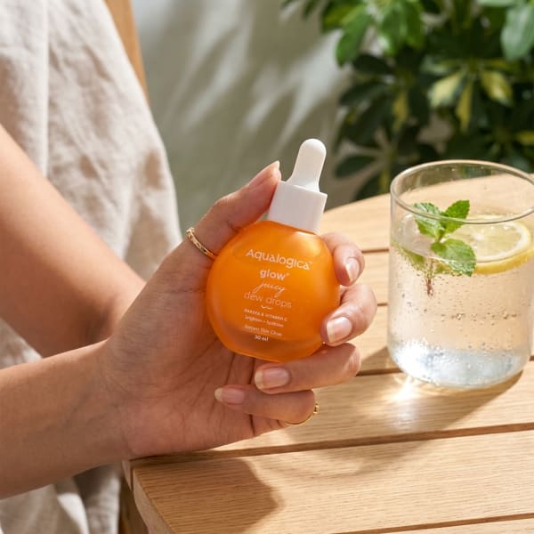Aqualogica FREEBIE - Glow+ Juicy Dew Drops 30 ml held in hand, candid photo