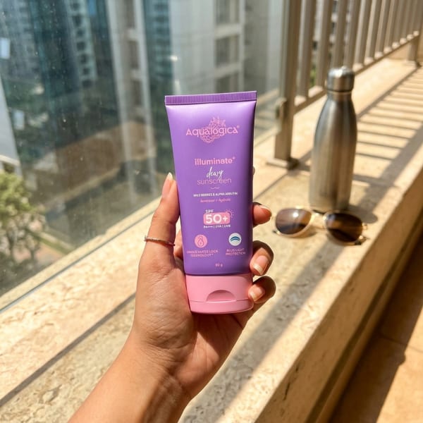 Aqualogica FREEBIE - Illuminate+ Dewy Sunscreen SPF 50+ PA++++  with Wild Berries & Alpha Arbutin -  80 g held in hand, candid photo