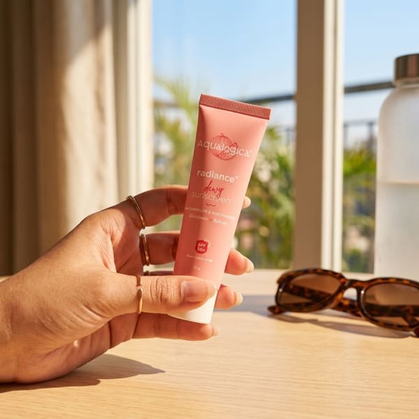 Aqualogica FREEBIE Radiance+ Dewy Sunscreen held in hand, candid photo