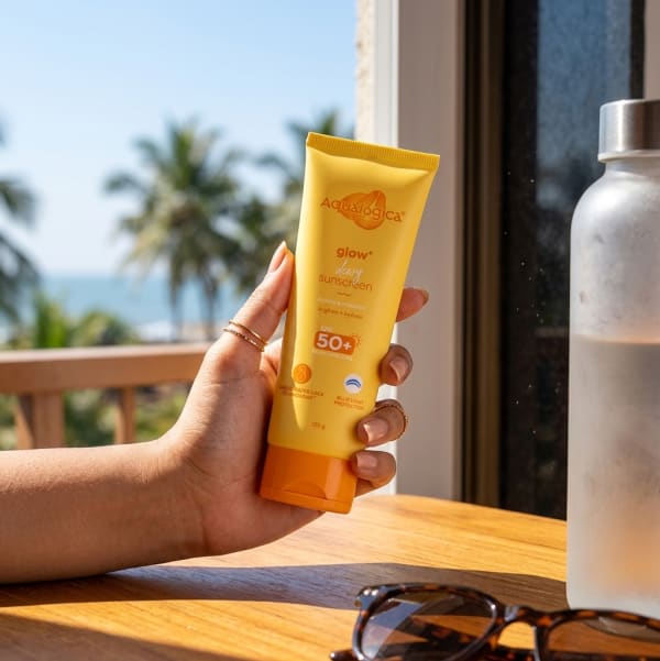 Aqualogica FREEBIE - Glow+ Dewy Sunscreen 125g held in hand, candid photo