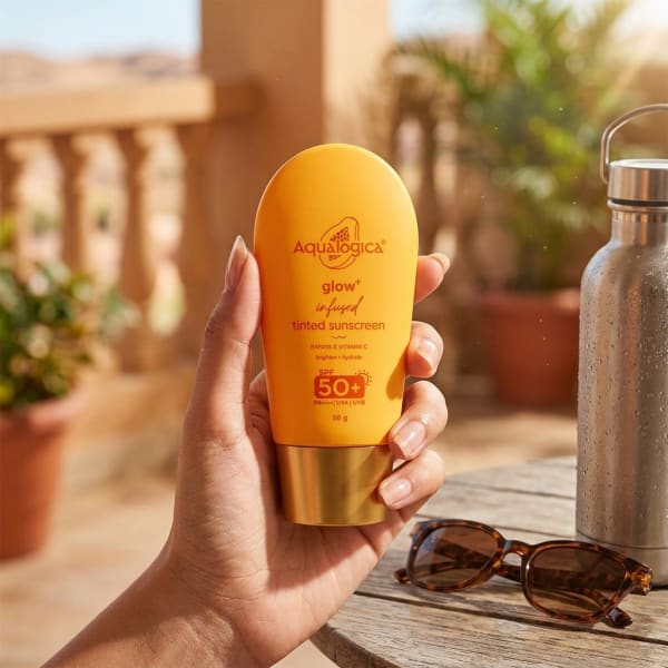 Aqualogica Exclusive - Glow+ Infused Tinted Sunscreen With Papaya & Vitamin C held in hand, candid photo
