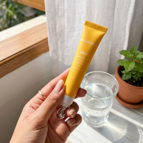 Aqualogica Glow+ Luminous Under Eye Gel 20 g held in hand, candid photo