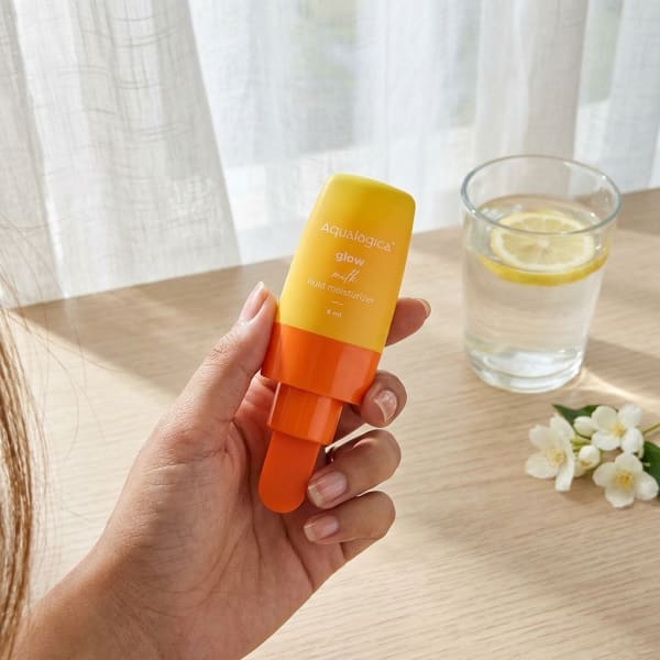 Aqualogica FREEBIE - Glow+ Milk Fluid Moisturizer- 8ml held in hand, candid photo