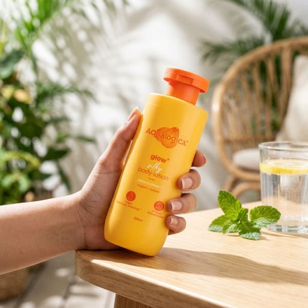 Aqualogica Glow+ Silky Body Lotion for 24-Hour Moisturization with Papaya & Vitamin C- 200 ml held in hand, candid photo
