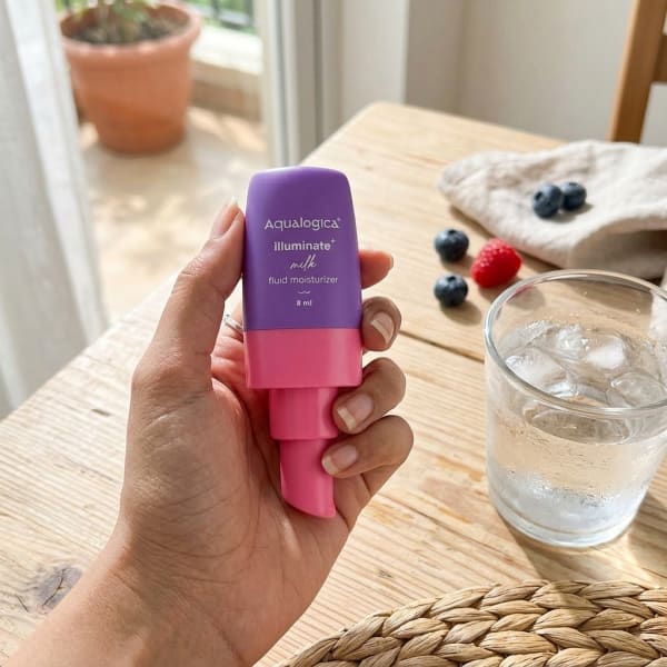 Aqualogica FREEBIE - Illuminate + Milk Fluid Moisturizer - 8ml held in hand, candid photo