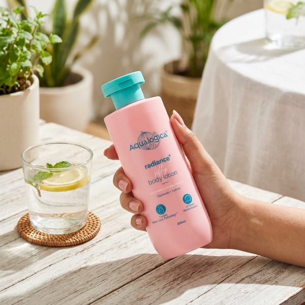Aqualogica Radiance+ Silky Body Lotion 200 ml held in hand, candid photo
