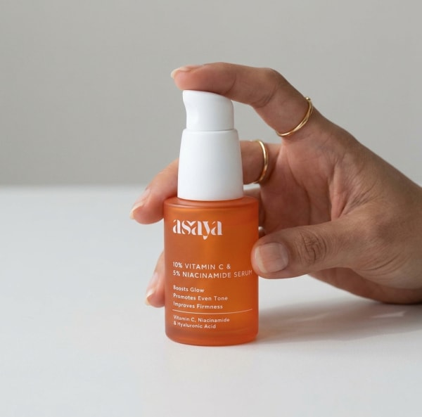 World of Asaya 10% Vitamin C & 5% Niacinamide Serum for Dry Dull & Uneven Skin held in hand, candid photo
