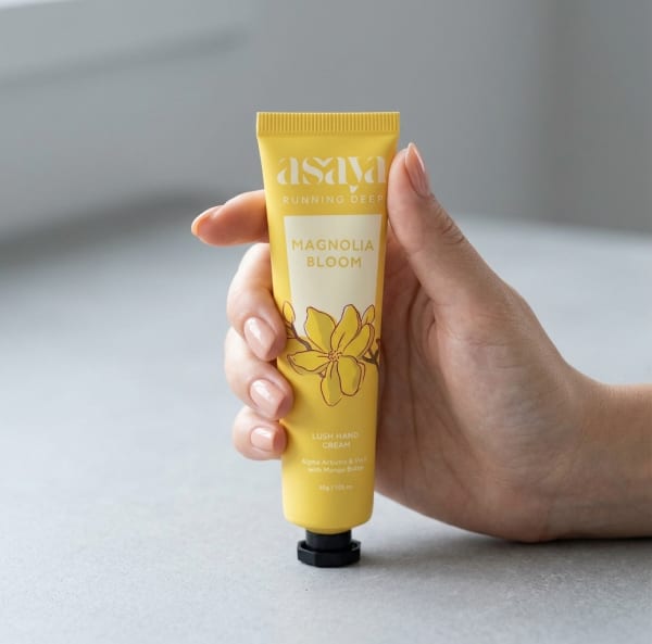 World of Asaya Lush Hand Cream held in hand, candid photo