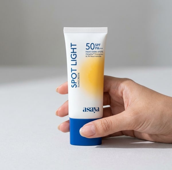 World of Asaya Spot Light Sunscreen SPF 50 PA++++ for Dark Spots & Hyperpigmentation held in hand, candid photo