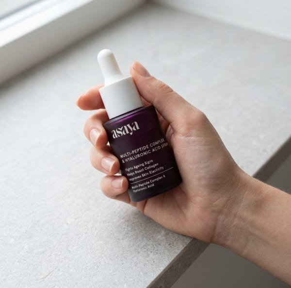 World of Asaya 5% Multi Peptide Complex & Hyaluronic Acid Serum for Face, Collagen Booster held in hand, candid photo