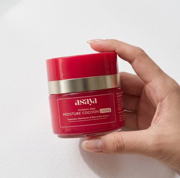 World of Asaya Moisture Cocoon Creme - Hydrating & Glow Moisturizer with Niacinamide held in hand, candid photo